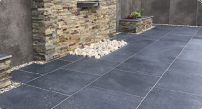 An outdoor patio made from black paving slabs.